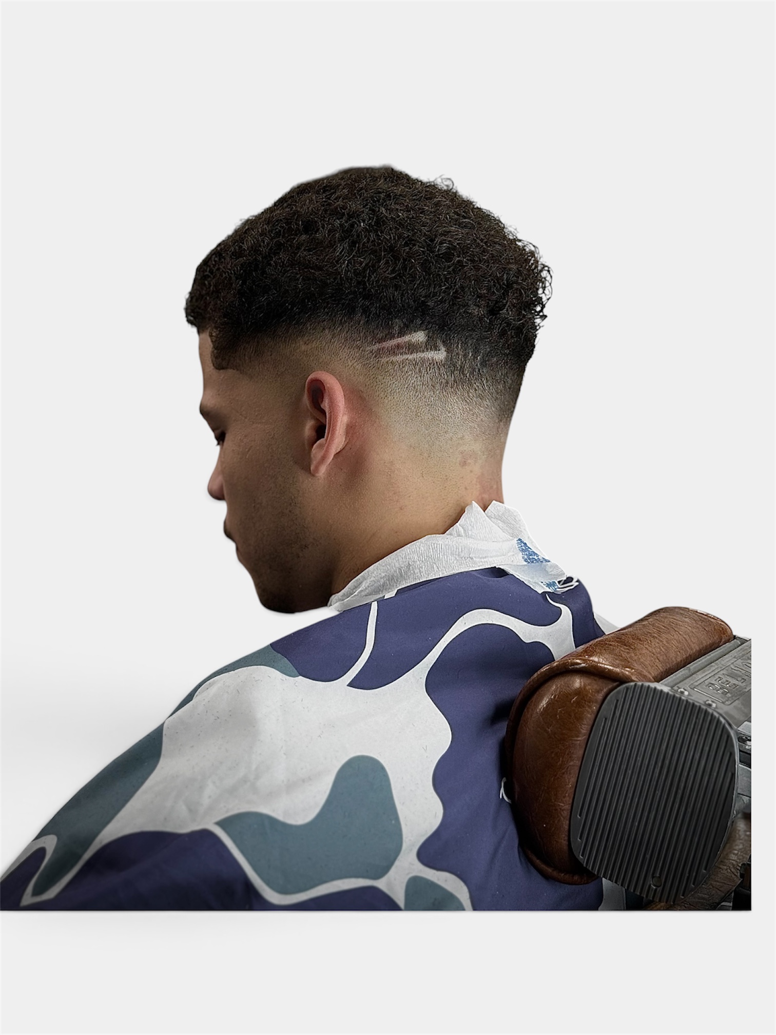 Curly top skin fade with line design at Fortis Barber Shop